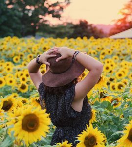 woman standing on a field of sunflowers